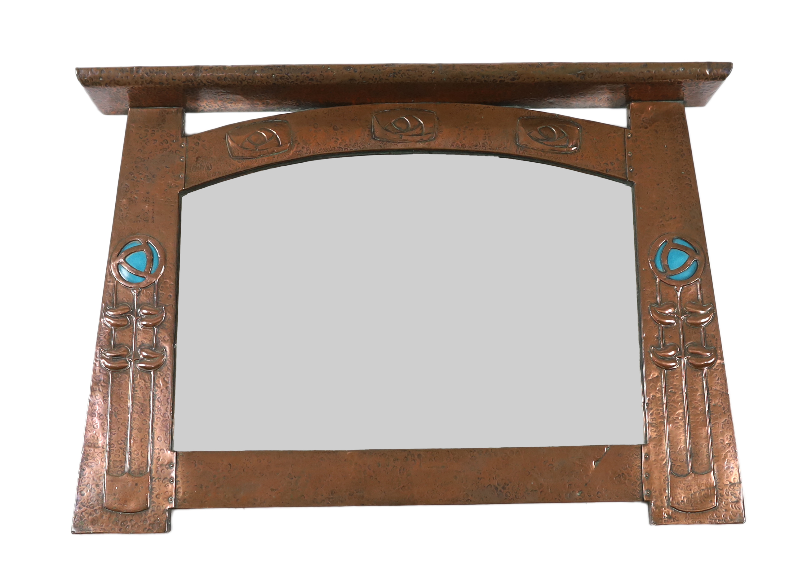 In the manner of Archibald Knox, a Scottish Arts & Crafts planished copper overmantel, 92cm wide, 65cm high